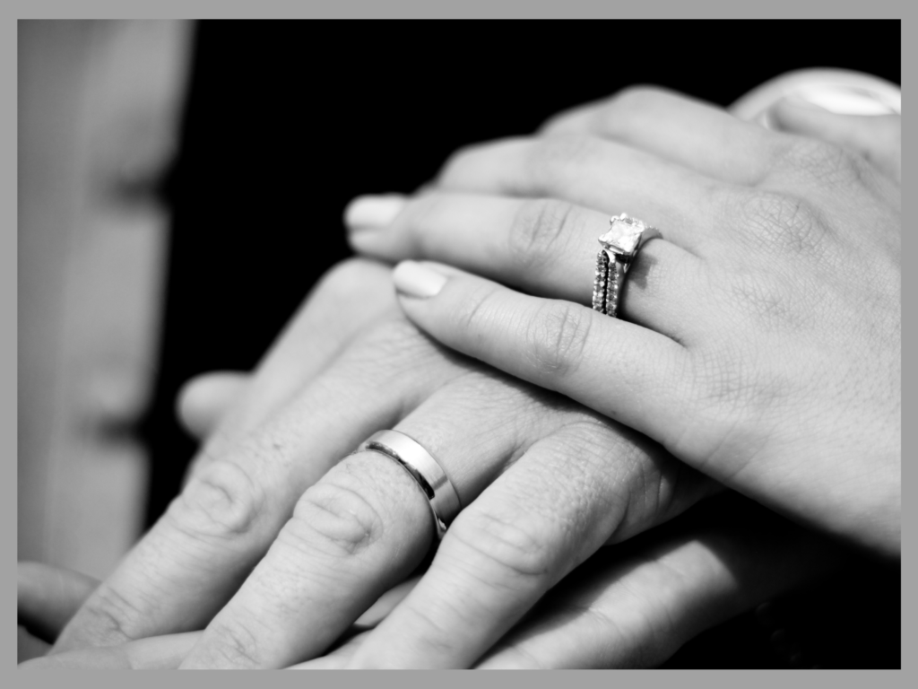 Newlyweds holding hands and showing thier wedding rings
